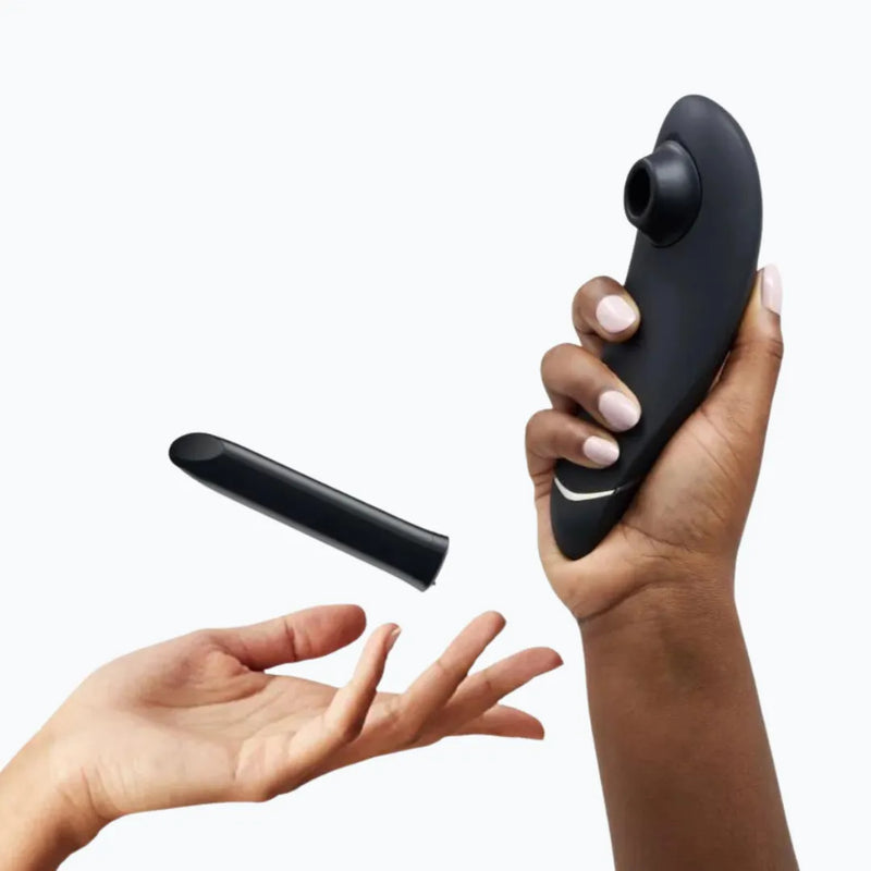 Hands_holding_black_clitoral_suction_vibrator_and_bullet_vibrator